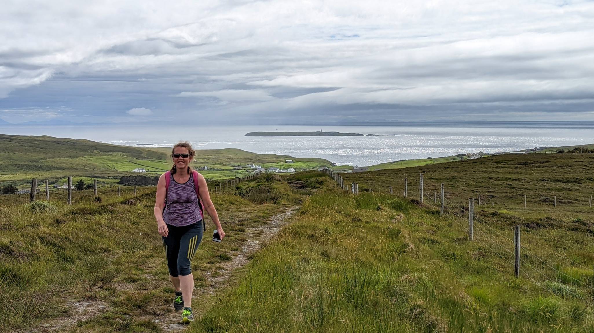 Woman walking on Malaidh Útha; Rathlin O'Byrne island in the background
