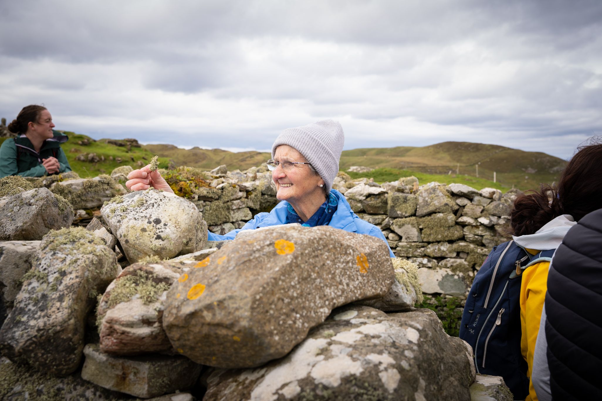 Caitlín Bn Mhic Fhionnghaile examines a piece of moss at Colmcille's Chapel